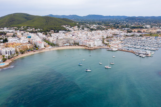 这是西班牙伊比沙岛美丽的无人机拍摄的照片，在一个炎热阳光明媚的夏日，海边金色的沙滩上，人们在放松和日光浴图片下载