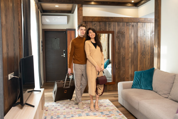 快乐年轻的亚洲女人和她的丈夫看酒店房间的内部图片下载