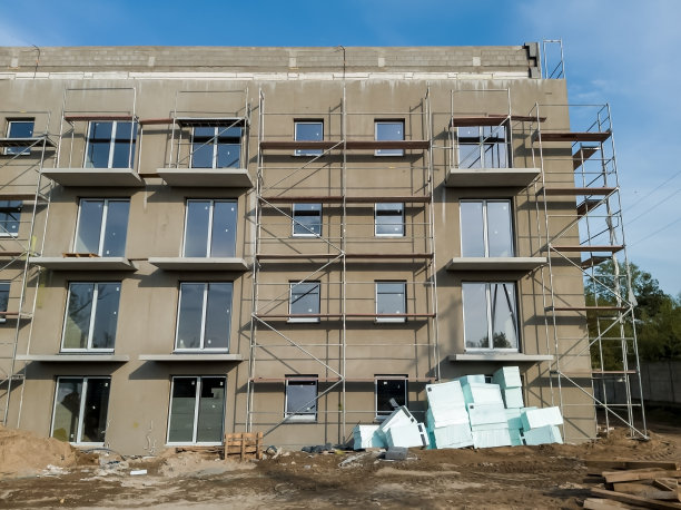 聚苯乙烯泡沫板堆放在新公寓楼的新抹灰立面前图片下载