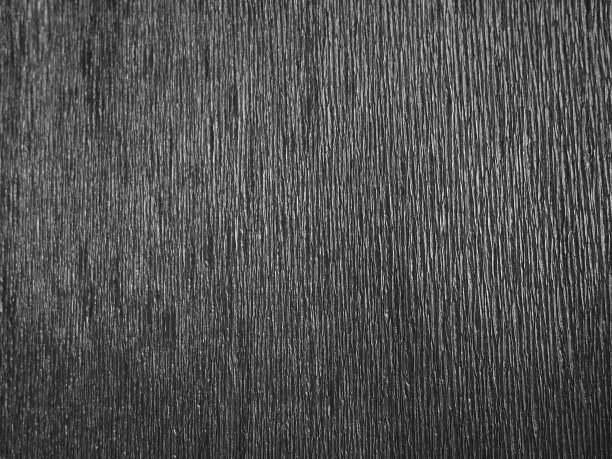 黑色或灰色瓦楞纸。不均匀的表面。抽象的单色背景。纸的波纹边缘。照明梯度。瓦楞结构。图片下载