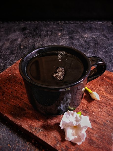 用黑色的玻璃杯和木制的背景喝茉莉花茶。库存图片图片下载