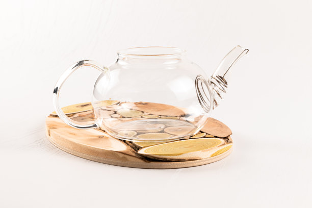 白色木桌上放着一个木制杜松子上的空玻璃茶壶图片下载