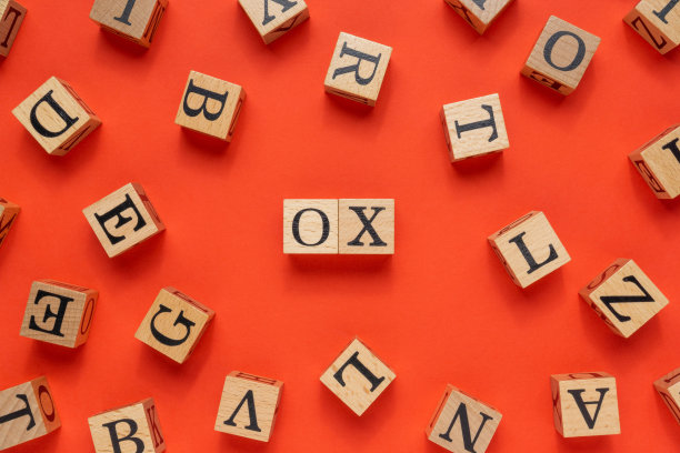 木块上的牛字。平躺在红色的背景上。图片下载