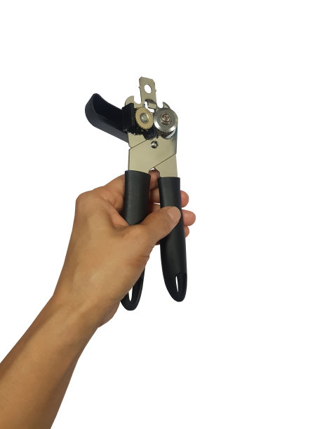 手拿着一个食物罐头开瓶器，背景是白色。剪切路径。图片下载