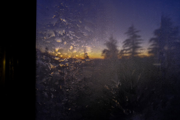 薄雾映窗，夕阳映在山间松林。自然背景。图片下载