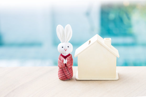 白色的兔子穿着传统的日本红衣服和木制房子在模糊的蓝色水背景图片下载