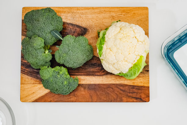 菜花和花椰菜近距离从木砧板直接从浅灰色的背景图片下载