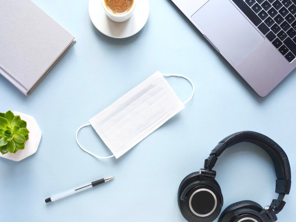 平铺排版用医用口罩笔记本电脑，咖啡，笔记本电脑上的蓝色背景。概念远程学习和在家工作，远程工作，自由职业，隔离。远程在线学习。图片下载