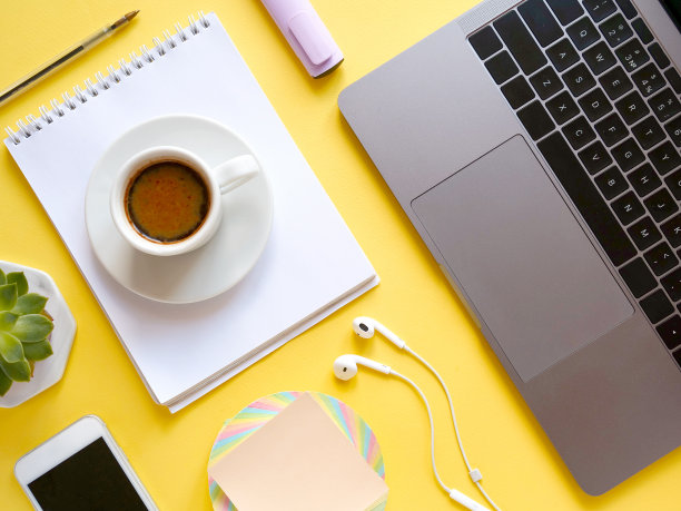 用笔记本电脑、笔记本、钢笔、咖啡、植物等平铺构图在黄色的背景上。概念远程学习和在家工作，远程工作，自由职业，隔离。休息时间，办公桌图片下载