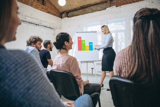 女演讲者在讲习班大厅演讲。观众或会议厅。未被认出的参与者的后视图。图片下载