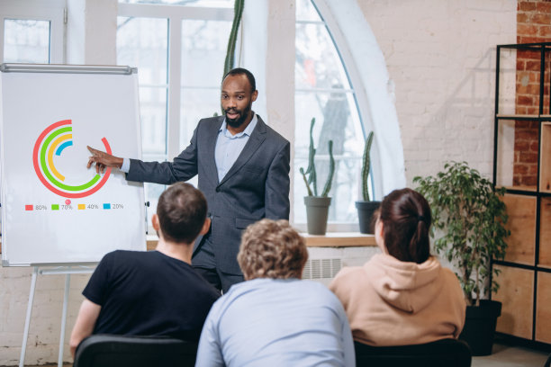 男演讲人在车间大厅演讲。观众或会议厅。未被认出的参与者的后视图。图片下载