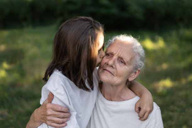 慈祥的孙女和奶奶拥抱在一起。图片下载