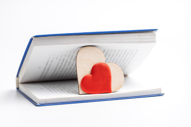 打开里面有心形符号的书。爱阅读的概念。情人节贺卡概念图片下载