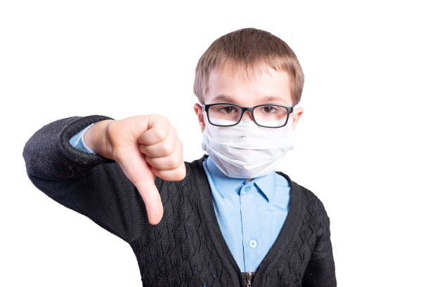 戴着面具和眼镜的男孩表现出拇指向下。孤立在白色背景上。图片下载