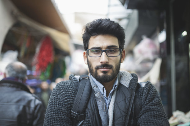 一个英俊的年轻人在城市街道上的肖像图片下载