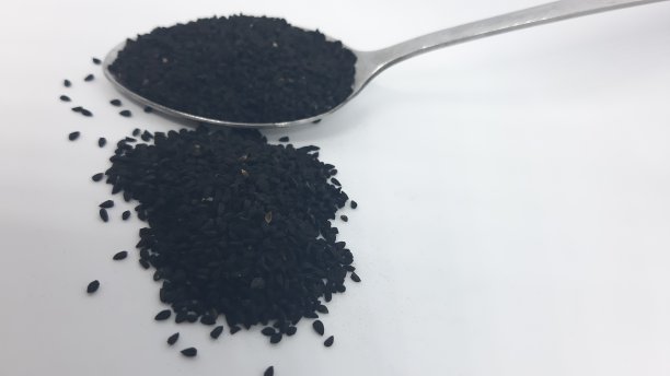 黑豆或黑孜然放在不锈钢勺上图片下载