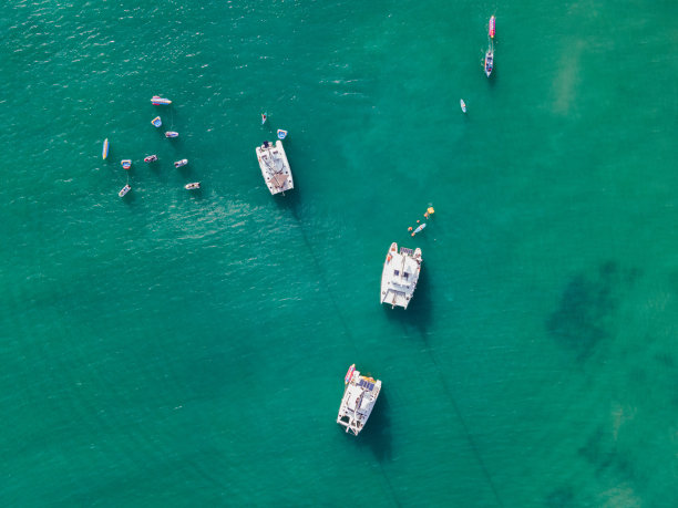 顶视图的游艇航行与水上摩托艇和香蕉船在热带海上图片下载