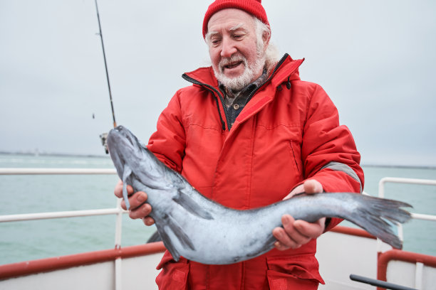 一个老人在船上抓着鱼图片下载