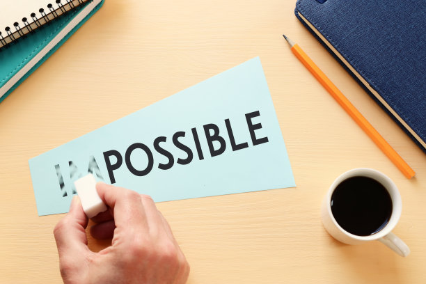 男人抹去卡片上的文字是不可能的，切掉单词im，这样它写起来是可能的。成功与挑战的概念。图片下载