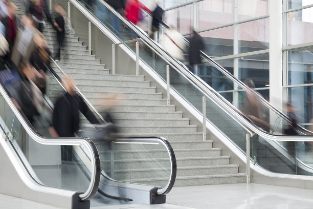 在现代玻璃室内的自动扶梯上模糊的人图片下载