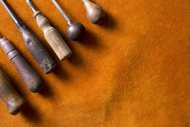 深红棕色麂皮工作围裙提供了一个合适的背景，一些古董工具，所有与木制把手。图片下载