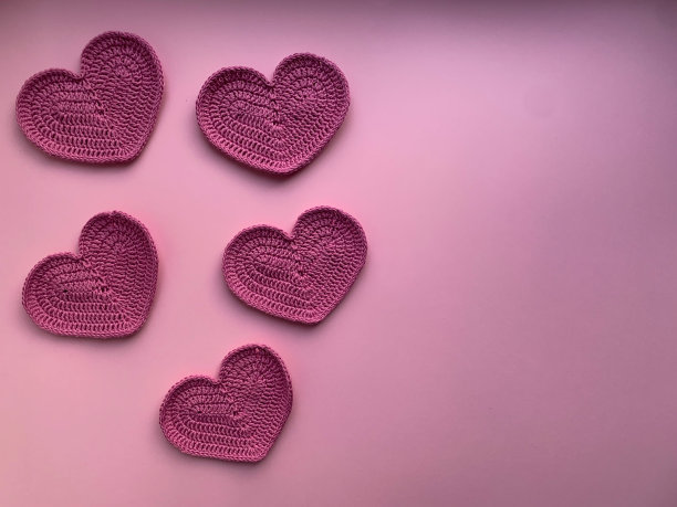 在粉红色的背景上编织粉红色的心。从上面的照片。创造产品的概念。钩编。情人节图片下载
