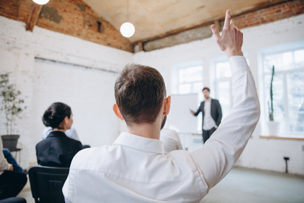 男演讲人在车间大厅演讲。观众或会议厅。未被认出的参与者的后视图。图片下载