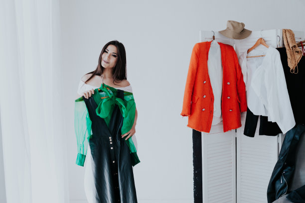 肖像的快乐年轻微笑的黑发女人选择服装从衣柜时尚的衣服图片下载