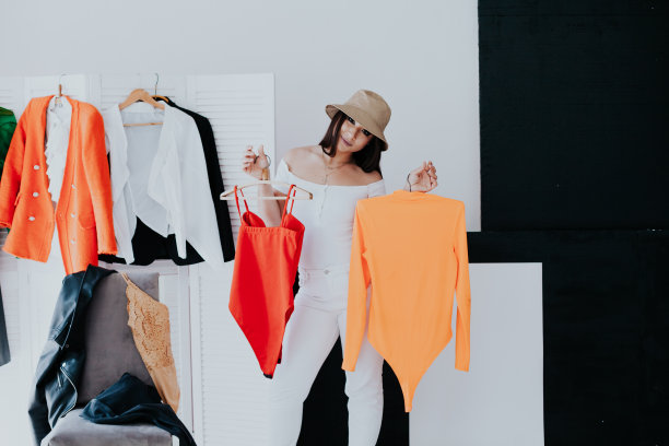 肖像的快乐年轻微笑的黑发女人选择服装从衣柜时尚的衣服图片下载
