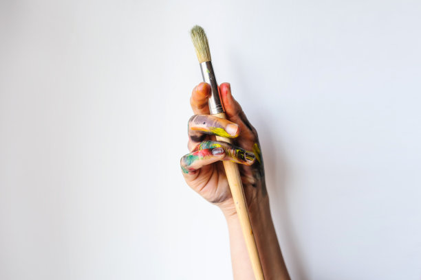 一个艺术家/画家的手拿着画笔的特写图片下载