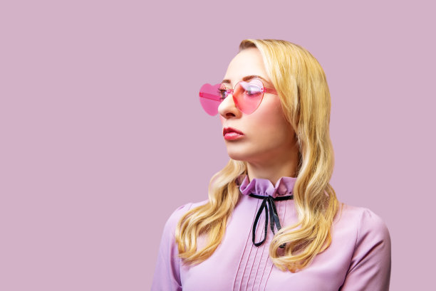 美丽的女孩长头发，粉红色的背景，情人节图片下载