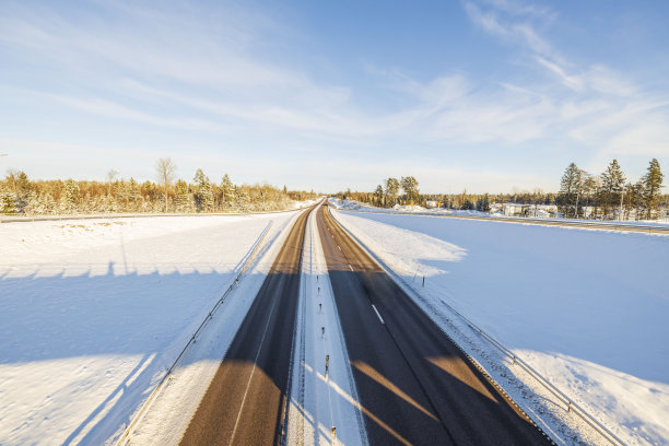 冬季高速公路上的美景。在明亮的冬日，田野上覆盖着白雪和蓝天。美丽的自然背景。瑞典。图片下载
