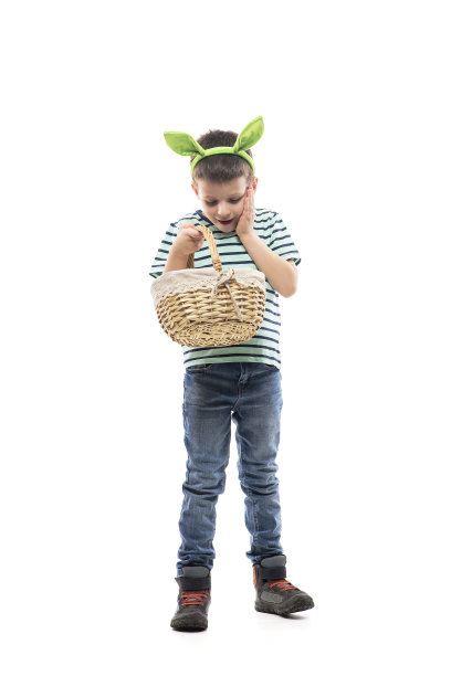快乐着迷的小男孩骄傲地看着篮子里装满了复活节后的鸡蛋图片下载