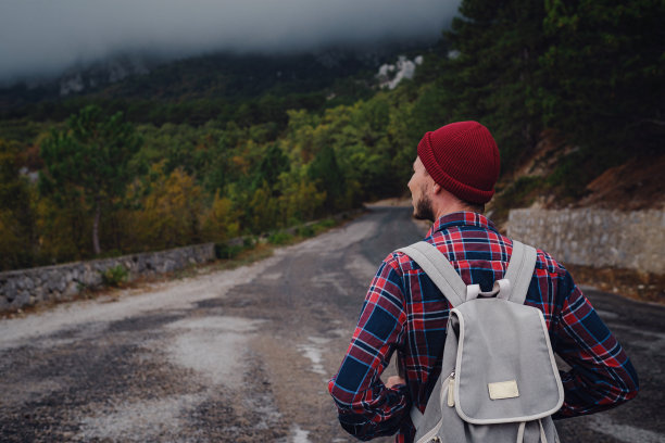 男子背包旅行在山里徒步旅行。图片下载