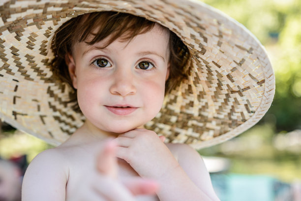 戴着太阳帽的孩子看着照相机图片下载