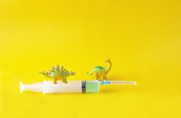 有趣的恐龙雕像和医用注射器图片下载