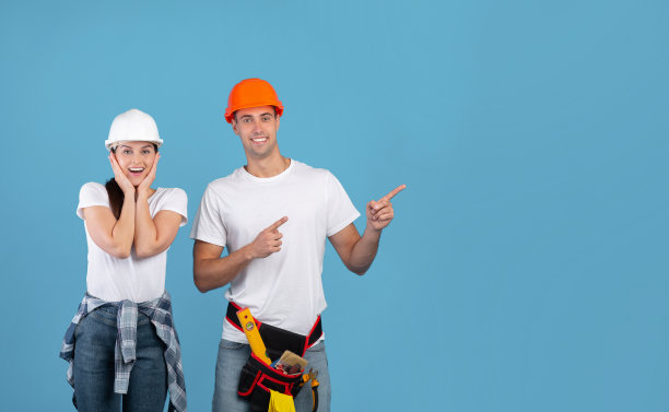 戴着安全帽的兴奋青年男女指着拷贝空间图片下载