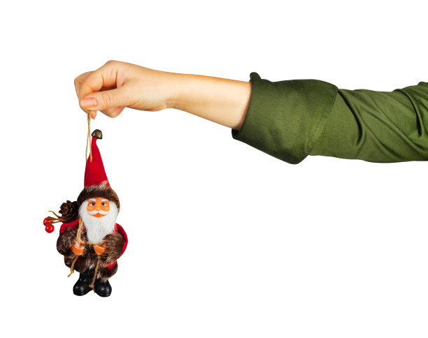 孤立的照片，一个女孩手在绿色衬衫抱圣诞老人小雕像。图片下载