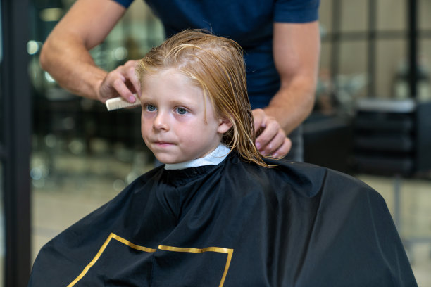 一个男孩在理发店理发和造型图片下载