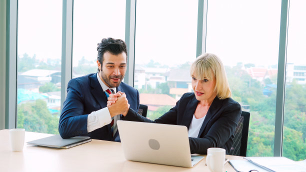 两个快乐的商业人士在办公室庆祝图片下载