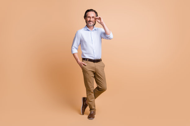 男孩的全长照片手口袋看相机穿眼镜衬衫裤子鞋孤立的米色背景图片下载