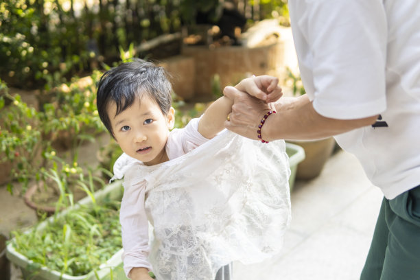 一个小女孩在她妈妈的帮助下穿衣服图片下载