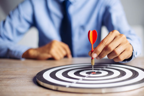 商人手持飞镖瞄准目标中心商业目标概念-商业目标，瞄准，焦点概念，隐喻目标营销或目标箭到商业成功的概念。图片下载