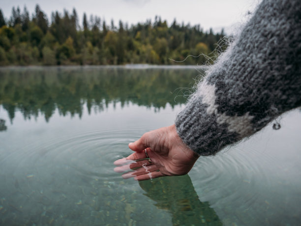 手从高山湖舀水图片下载
