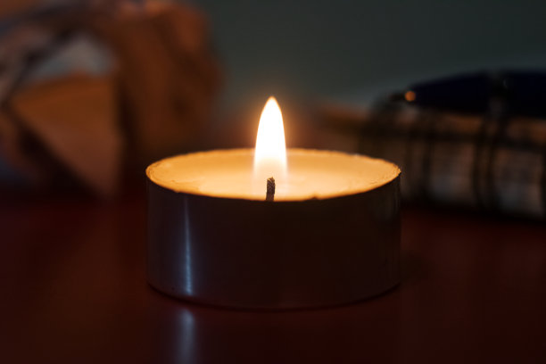 燃烧的蜡烛特写在笔记本的背景上图片下载