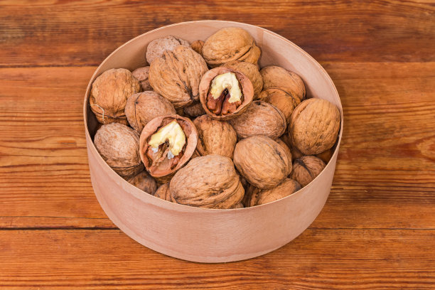 胡桃壳装在木盒里，放在质朴的桌子上图片下载