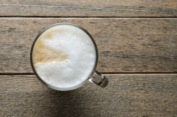 俯视图卡布奇诺咖啡杯与发泡奶油在木板的背景。图片下载