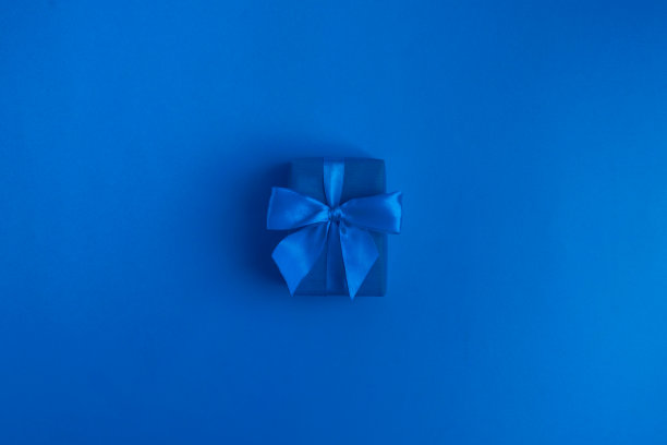 蓝色礼盒与蓝色丝带在经典的蓝色背景。时尚的颜色图片下载