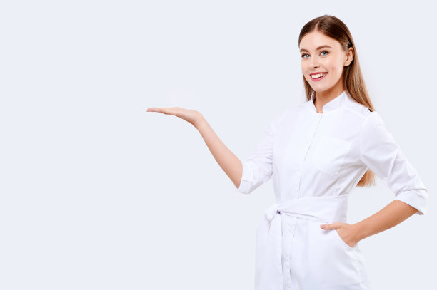 身穿制服的医生在白色孤立的背景下，年轻的微笑护士展示着什么，医院工作人员图片下载