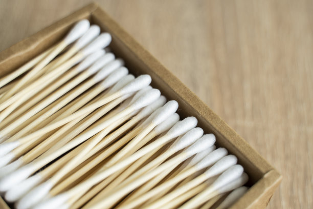 环保的棉签。桌子上放着一个装着可回收的竹棉花蕾的纸箱。“零浪费”的概念。生态产品。化妆棒放在盒子里。清洁耳朵的木棒。图片下载